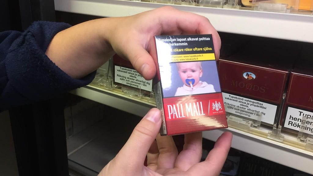 Tupakka-askien varoituskuvat-myyjän kädet lähis