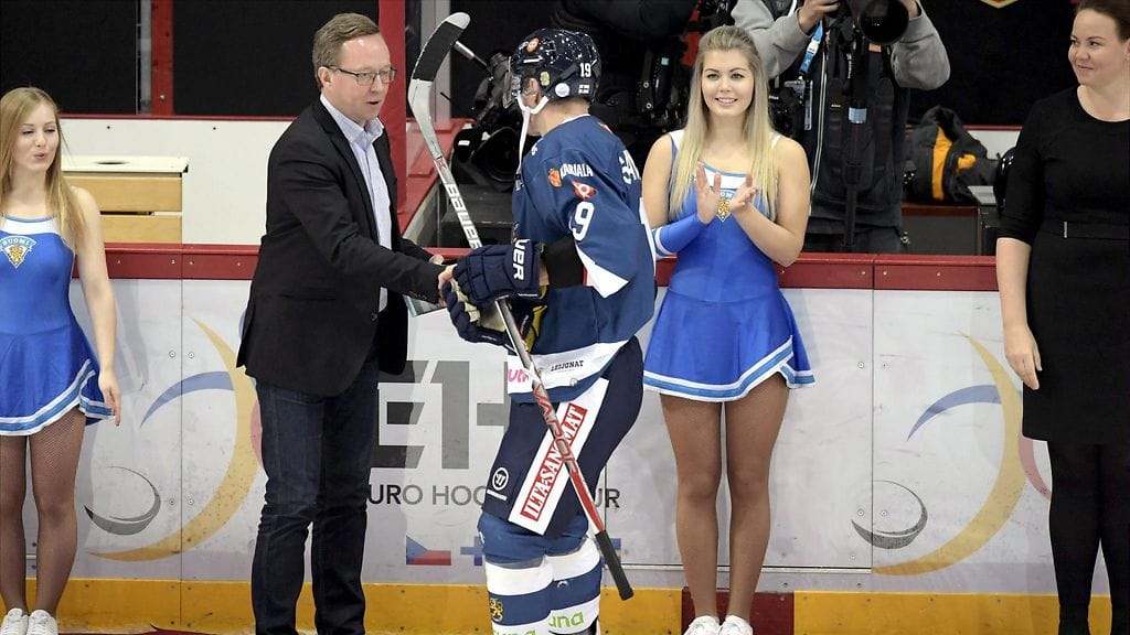 Elinkeinoministeri Mika Lintilä palkitsi Veli-Matti Savinaisen Ruotsi-ottelun jälkeen.