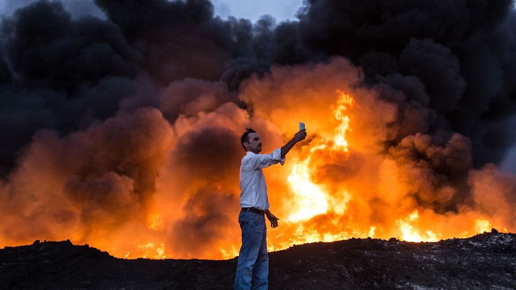 Kuvituskuvaa juttuun, kuvan tulipalo ei liity uutiseen. Mies otti selfietä 19. lokakuuta 2016 Qayyarahin alueella 60 kilometriä etelään Mosulista, jossa Irakin armeijan hyökkäys kaupungin valtaamiseksi Isisiltä oli käynnissä.