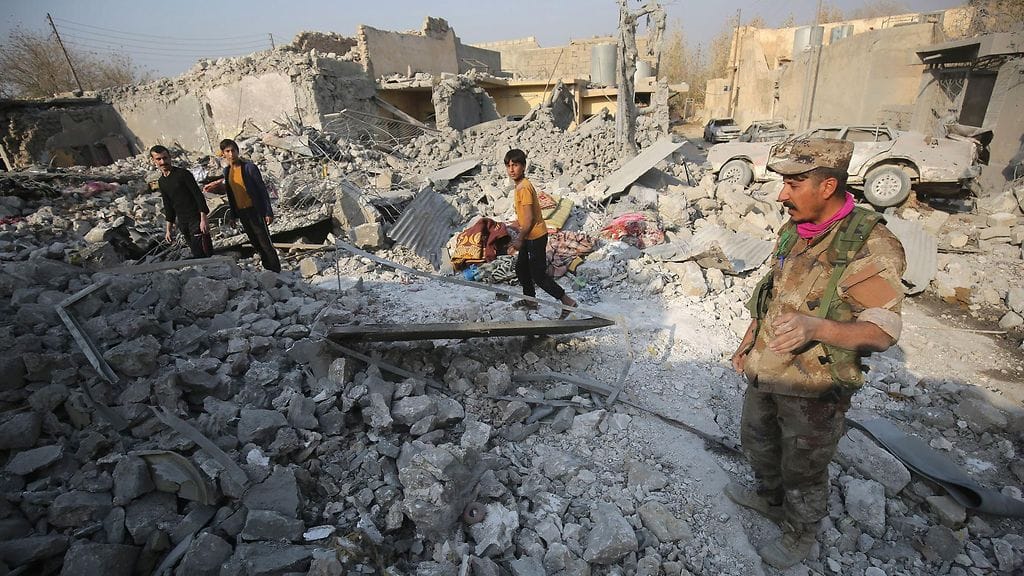 Irakilaiset tarkastivat tuhoja iskujen jälkeen Mosulin liepeillä Hamam al-Alilin alueella 7.11.2016.