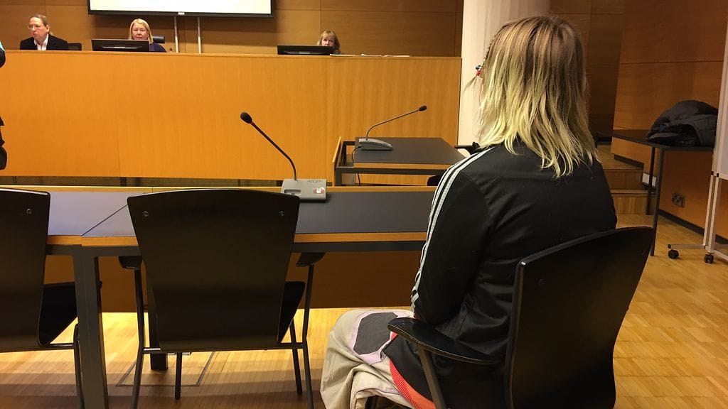Koulusurman valmistelusta epäilty nainen saapui oikeuteen peittämättä kasvojaan.