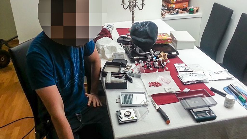 Douppikauppa-huumekaupasta syytetyn miehen veli poseeraa maahan tuodun huume-erän vierellä.