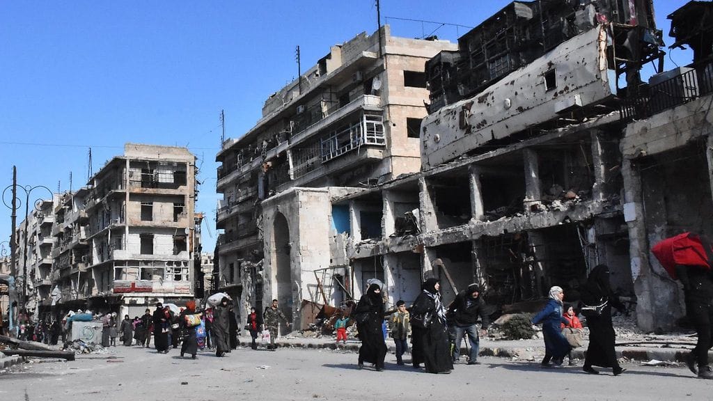 Syyrialaisia Aleppossa Bab al-Hadidin alueella kävelemässä koteihinsa Syyrian hallituksen joukkojen valvonnassa tänään.