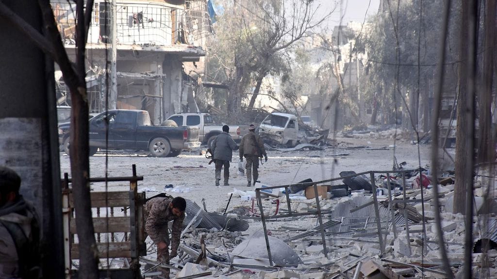 Syyrian Itä-Aleppo 11.12.2016. Kaksi Syyrian hallituksen joukkoihin kuuluvaa sotilasta kävelee al-Maadin alueella.