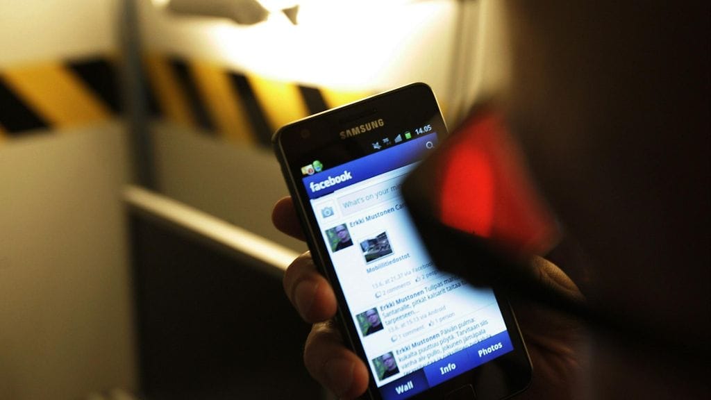 F-Securen tietoturva-asiantuntija Erkki Mustonen katsoo Facebook-profiiliaan kännykästä.