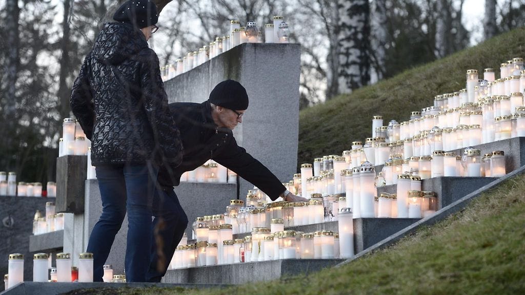 Ihmiset toivat kynttilöitä Hietaniemen hautausmaalle Menneiden sukupolvien muistolle -muistomerkille Helsingissä jouluaattona 24. joulukuuta 2015.