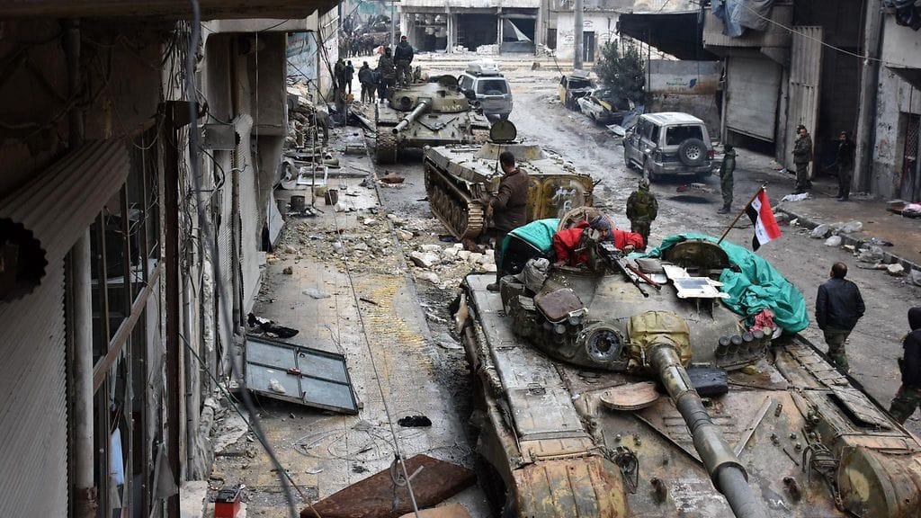 Syyrian hallitusta kannattavat joukot partioivat ilmaiskujen runtelemassa Aleppossa joulukuussa.