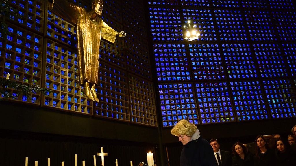 Saksan kulttuuriministeri Monika Gruetters kirjoittaa muistokirjaan Kaiser-Wilhelm-Gedaechtniskirche -kirkossa.