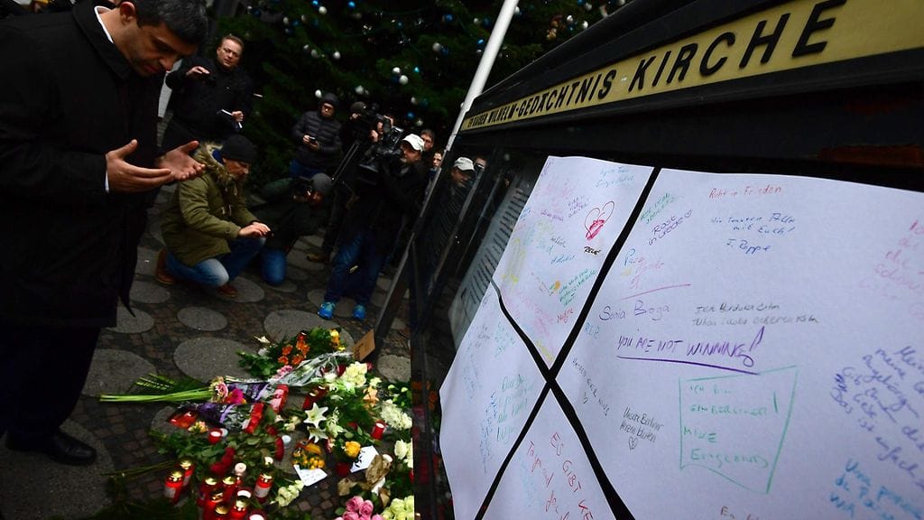 Saksalaisen SPD-puolueen puheenjohtaja Raed Saleh rukoulee Kaiser-Wilhelm-Gedaechtniskirche-kirkon -kirkon edustalla. Isku joulutyorille tapahtui kirkon lähettyvillä.