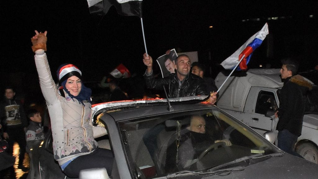 Syyrialaiset juhlivat Aleppossa sen jälkeen, kun Syyrian armeija ilmoitti saaneensa kaupungin takaisin haltuunsa.