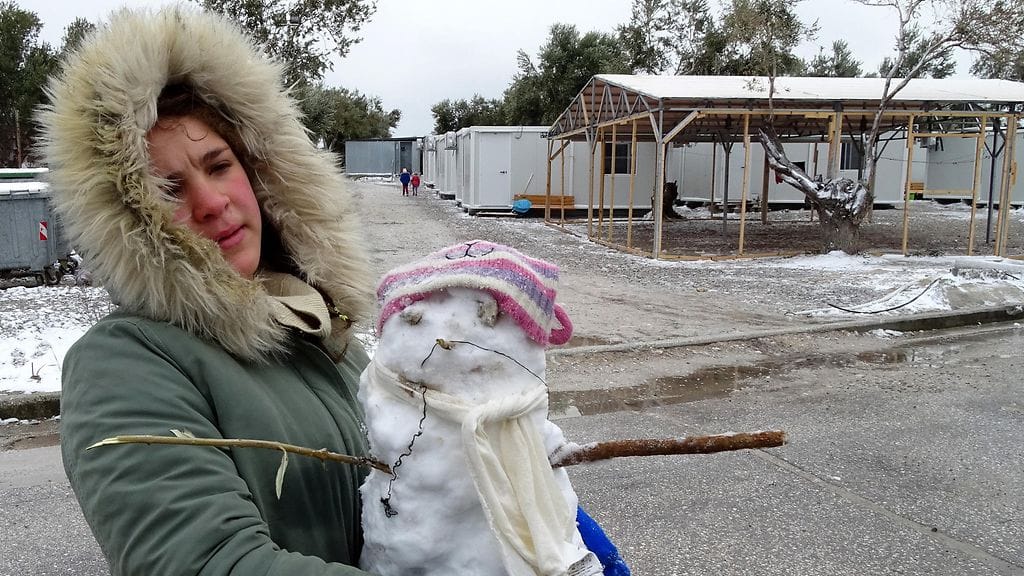 Nuori nainen kantoi lumiukkoa pakolaisleirillä Kreikassa.