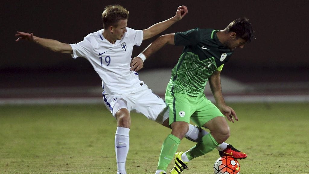 Jesse Tuominen vääntää pallosta Slovenian Martin Kramaricin kanssa.