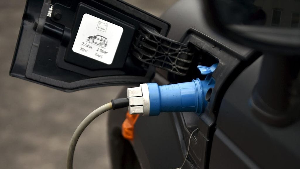 Sähköauto latauksessa. Kuvituskuva.