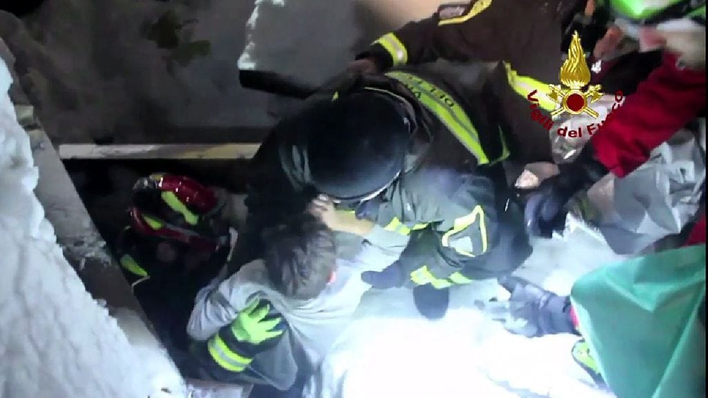 Poliisin kuvaa lapsen pelastamisesta italialaisen vuoristohotellin raunioista.