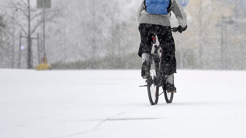 Pyöräilijä lumisella kadulla Helsingin keskustassa viime marraskuussa.