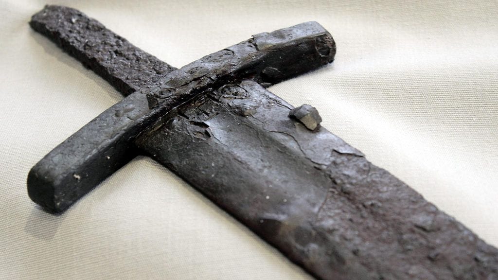 Väistimen alapuolella oleva risti. Päijät-Hämeen Asikkalasta viime vuoden toukokuussa löytynyt viikinkiaikainen miekka tekee paluun Lahden historialiseen museoon.