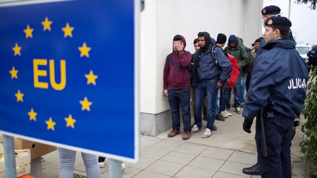 Pakolaisia odottamassa EU-kyltin takana Kroatiassa Serbian rajalla.