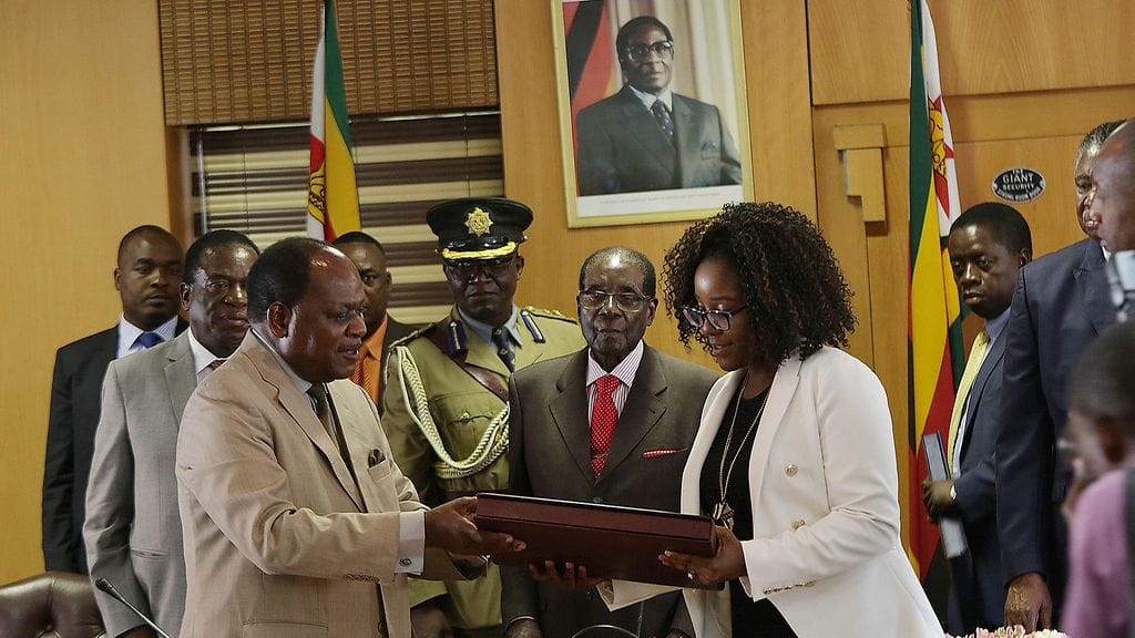 Zimbabwen presidentti Robert Mugaben seuraa sivusta, kun hänen tyttärensä  Bona vastaanottaa lahjan isänsä puolesta presidentille järjestetyissä 93-vuotisjuhlissa. Nämä juhlat järjestettiin varsinaisena syntymäpäivänä tiistaina.