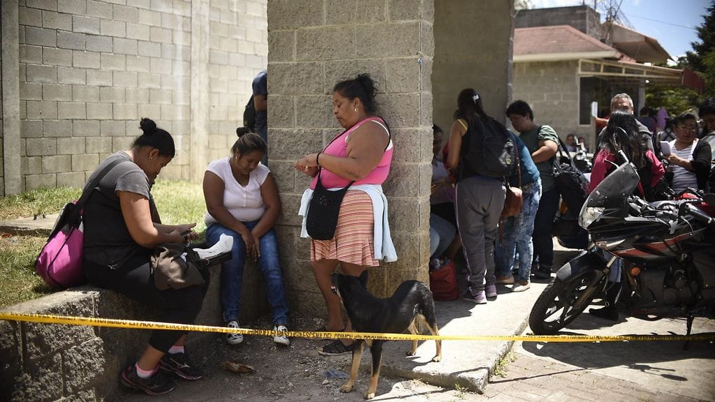 Sukulaisia suremassa orpokodin ulkopuolella sen jälkeen, kun lähes 20 ihmistä oli kuollut tuhoisassa tulipalossa.