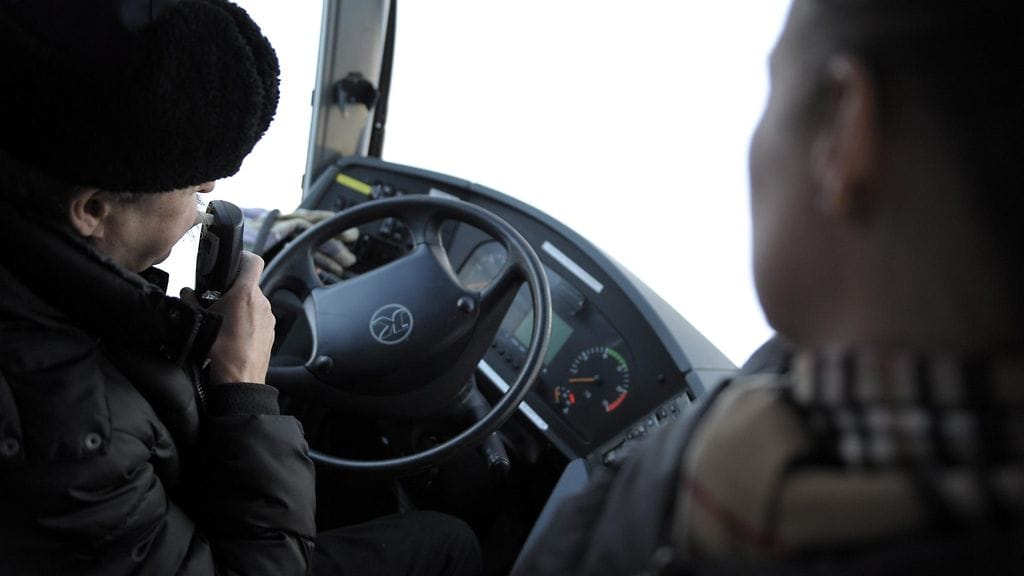 Linja-autonkuljettaja puhaltaa alkolukkoon ennen auton käynnistämistä.