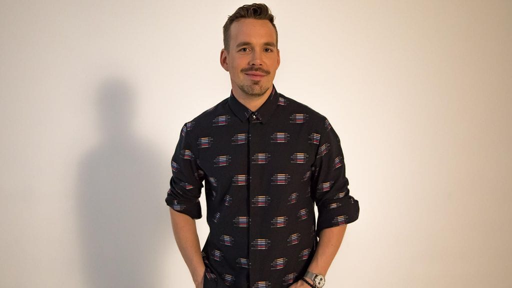 Teemu Muurimäki yllään suunnitelemansa malliston miesten paita.