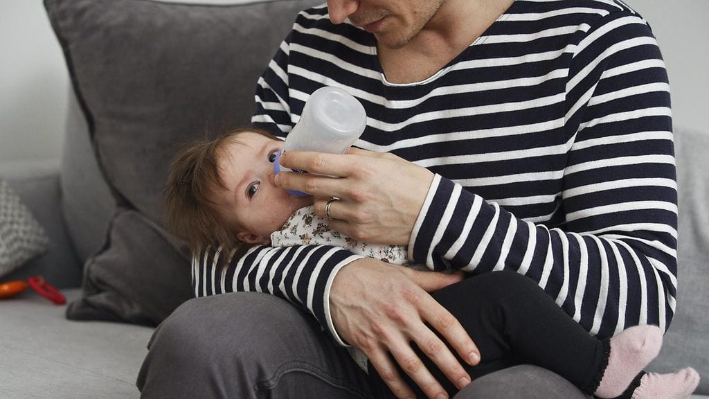 Isä hoitaa puolivuotiasta lasta. Kuvituskuva.