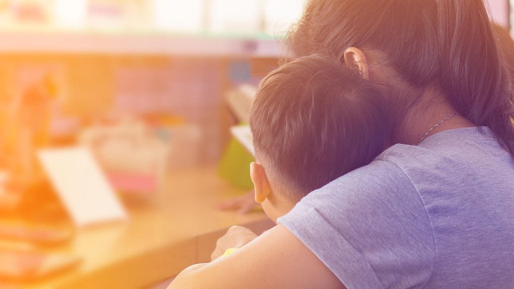 äiti lohduttaa lasta