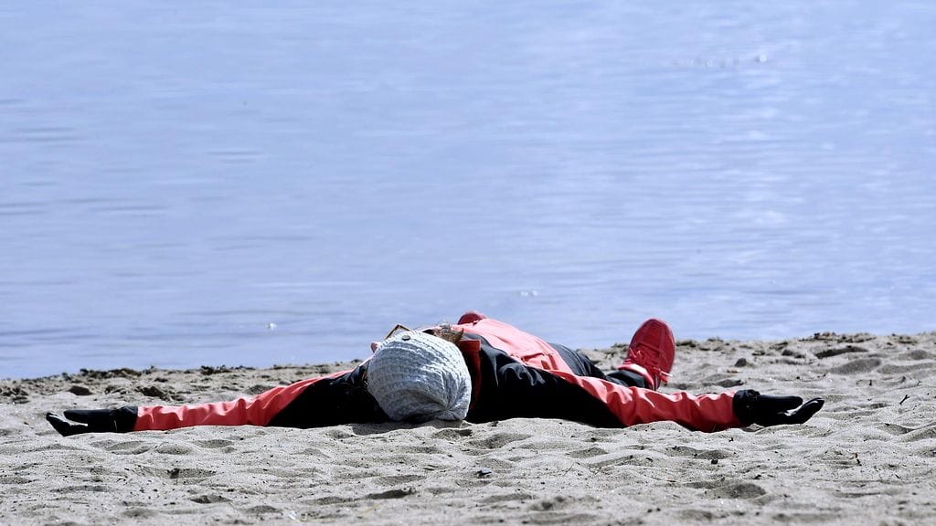 Rohkea auringonottaja meren rannalla Espoon Nokkalassa 15. huhtikuuta 2017.