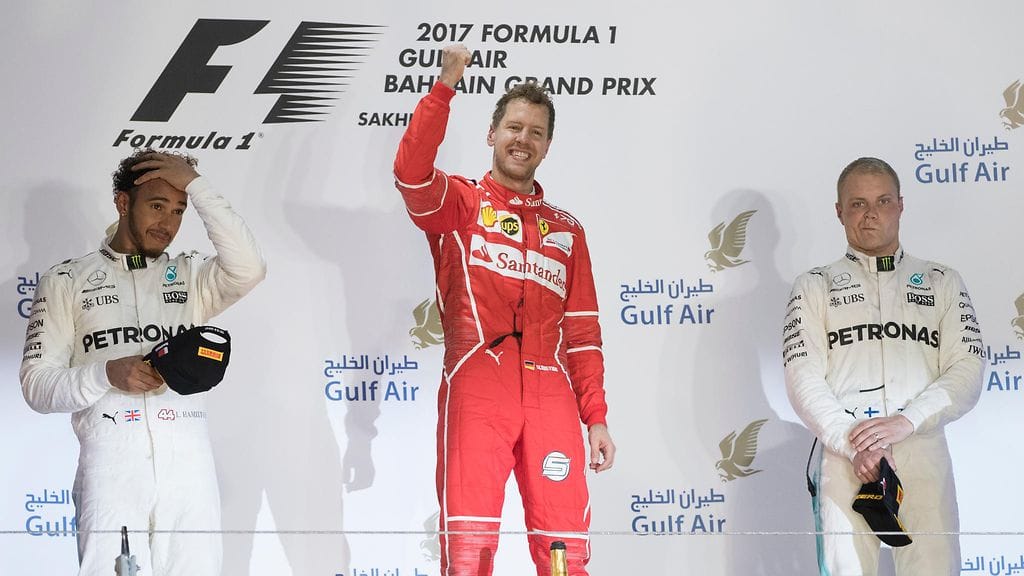 Ferrarin Sebastian Vettel (kesk.) johtaa MM-sarjaa.