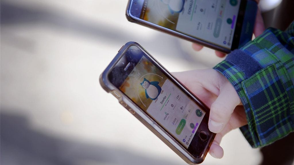 Kuvituskuvassa lapset pelaavat Pokémon Go -mobiilipeliä.