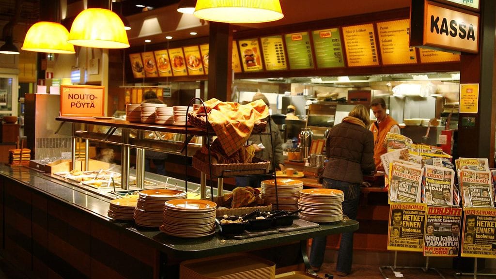 Moni perhe juhlii äitienpäivää huoltoaseman buffetissa.