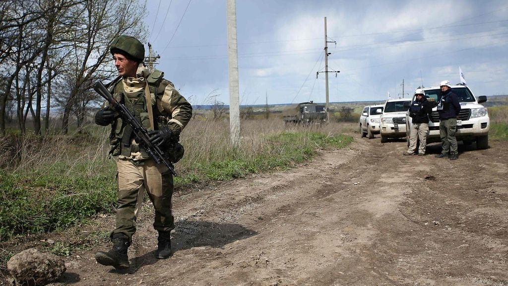 Itäukrainalaissotilas kulkee Etyj-tarkkailijoiden ohi lähellä Luhanskia.