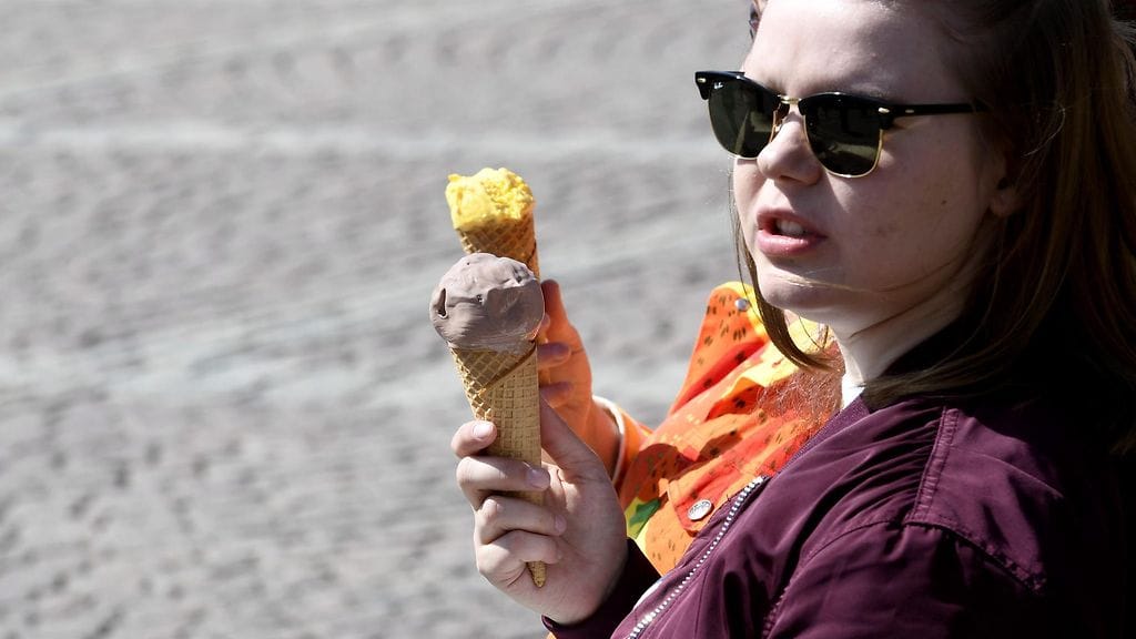 Ihmiset nauttivat jäätelötötteröistä ja kevätauringosta Senaatintorilla  Helsingissä perjantaina 19. toukokuuta 2017.