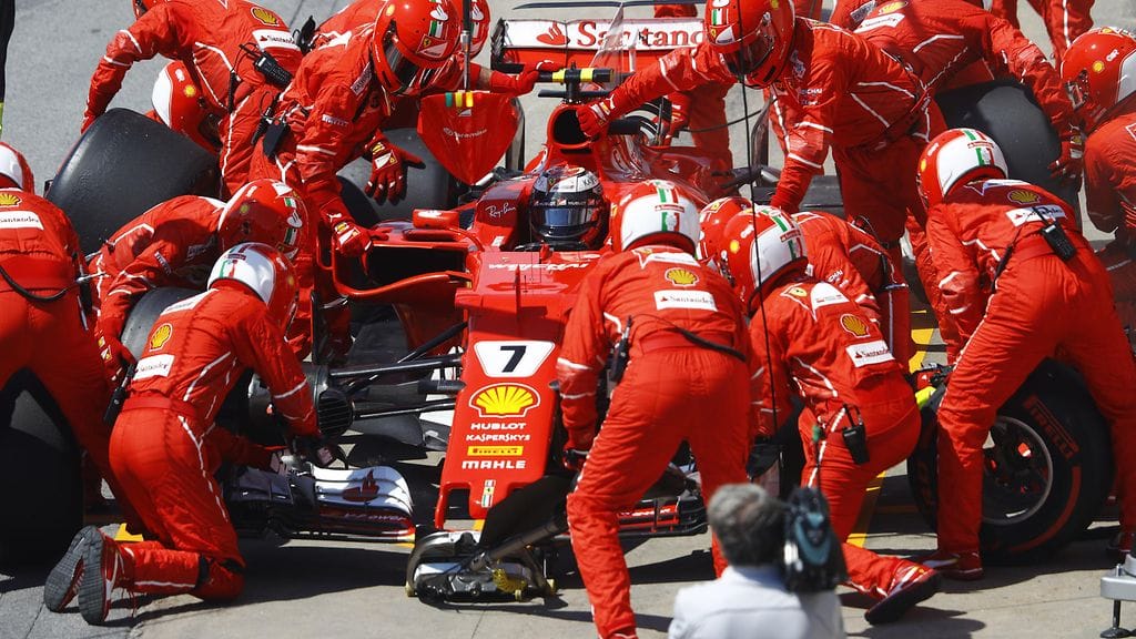 Ferrarin varikkoväki Kimi Räikkösen auton kimpussa.