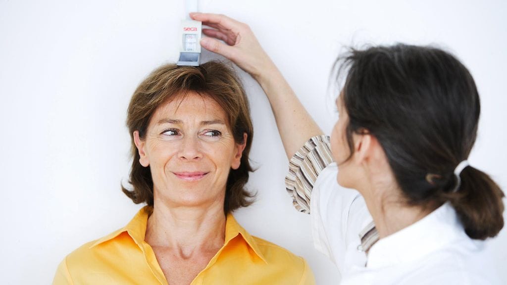 Pituus on hyvä tarkistaa säännöllisesti aikuisiälläkin, jotta mahdollista osteoporoosia päästään hoitamaan ajoissa. Kuvituskuva.