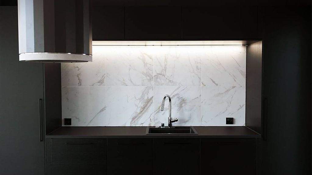 Trendikkäässä mustassa keittiössä katse kiinnittyy kauniiseen vaalean marmoriin.