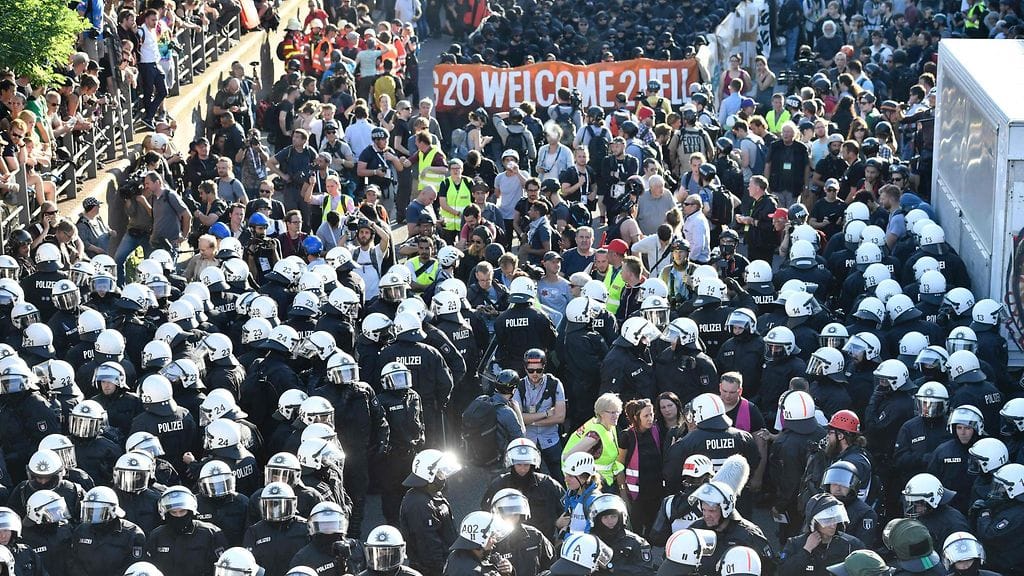 Hampuriin odotetaan jopa sataatuhatta mielenosoittajaa. KuvassaTervetuloa Helvettiin -mielenosoittajia ja mellakkapoliiseja Hampurissa tänään.