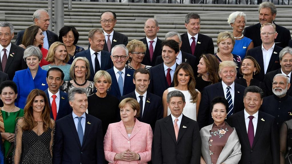 Saksan liittokansleri Angela Merkel ja hänen aviomiehensä Joachim Sauer poseeraavat G20-kokoukseen osallistuvien kanssa Hampurissa.