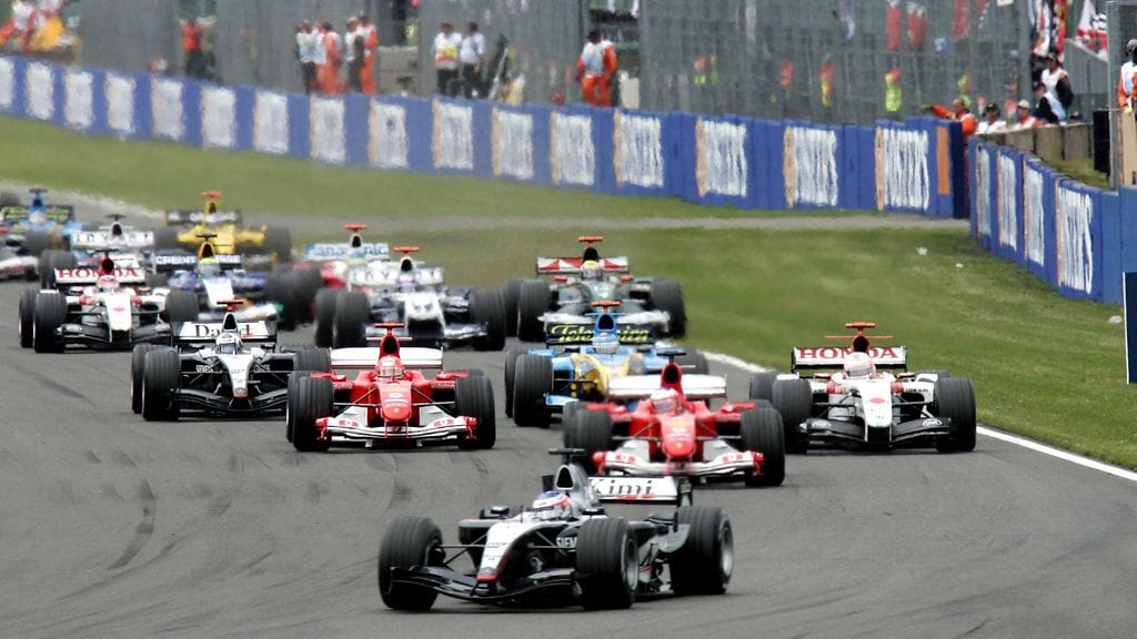 Kimi Räikkönen johdattaa F1-letkan Copse-mutkan läpi vuonna 2004. F1-autot ajoivat tuolloin mutkan läpi kaasu pohjassa.