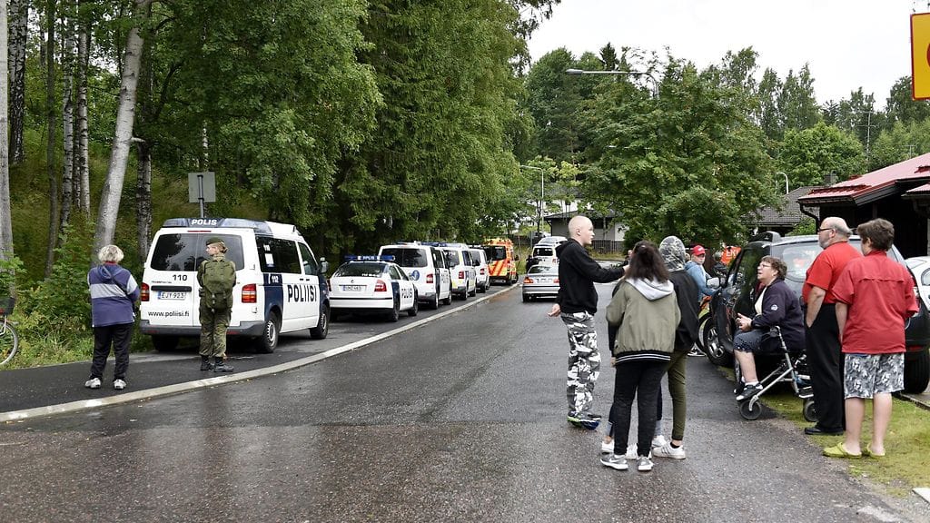 Paikallisia asukkaita ja poliisiautoja kadunvarressa Hakunilassa alkuillasta.