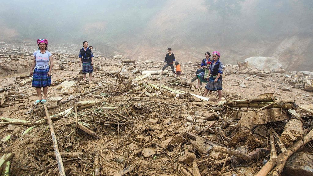 Ihmiset katsovat maanvyöryn ja tulvien myötä tuhoutuneita kotejaan. AFP/Lehtikuva.