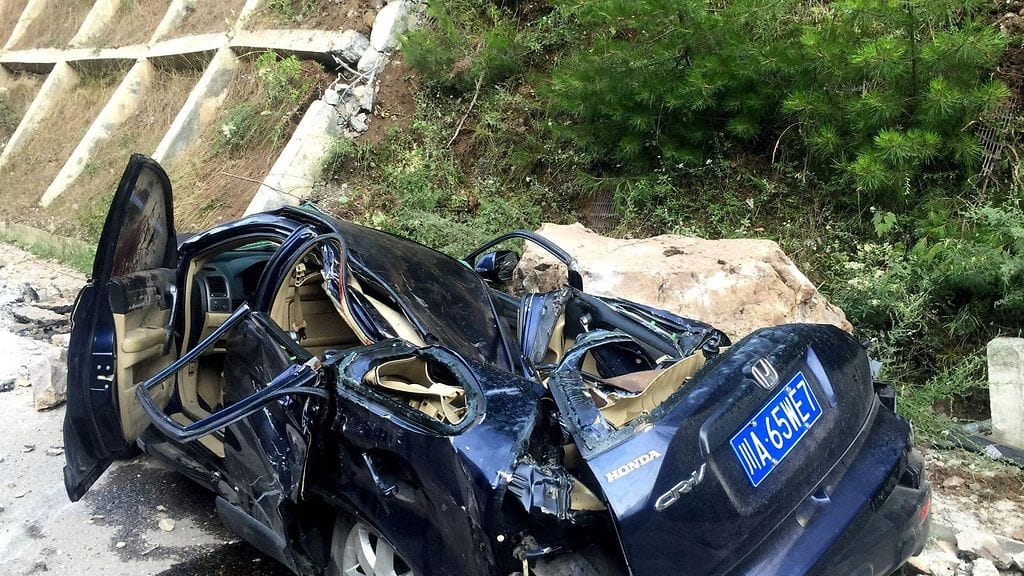 Maanjäristys teki autosta selvää jälkeä Jiuzhaigoussa.