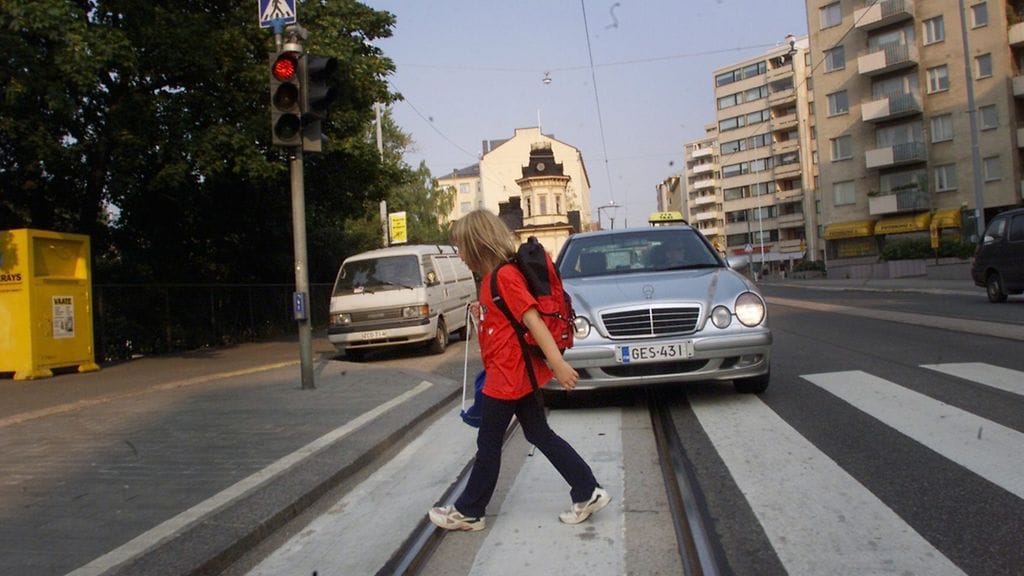 Pieni koululainen ylittää suojatietä. Arkistokuva.