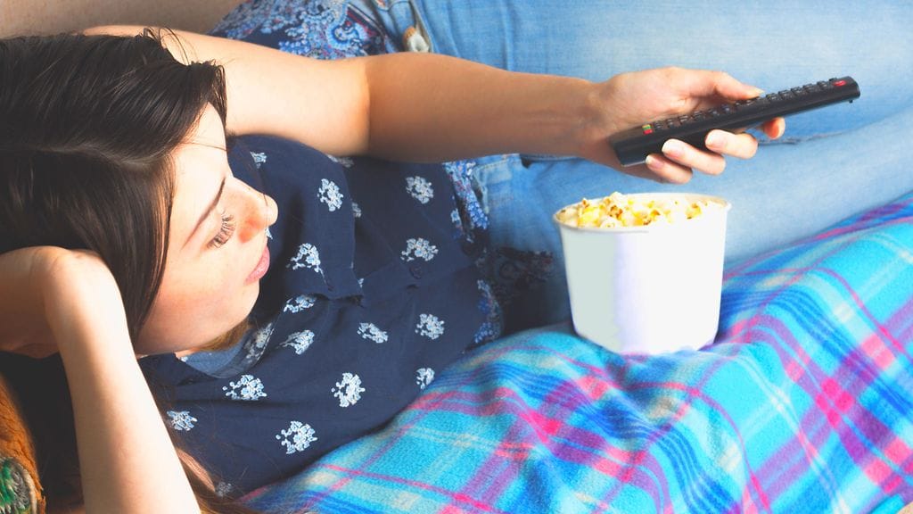 Kuvituskuva. Television ääressä napostelu houkuttelee uuvuttavan päivän jälkeen.