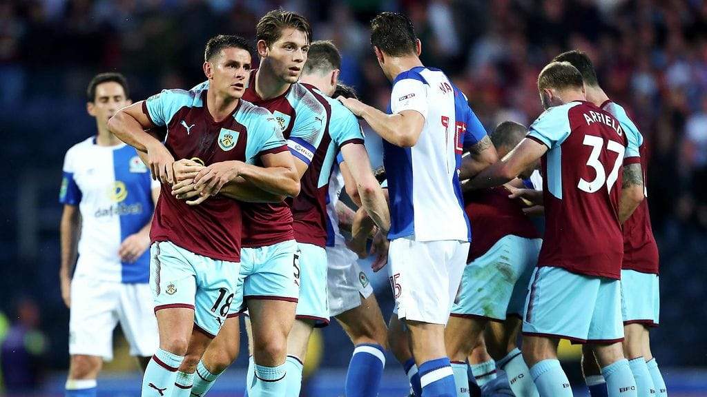 Joukkuetoveri tuli Ashley Westwoodin (vas.) tueksi, kun Blackburnin fani (maassa) hyökkäsi tämän kimppuun.