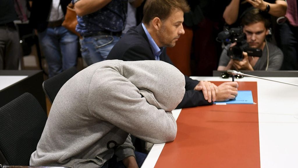 Monsif Bakir peitti oikeussalissa kuvaustilanteessa kasvonsa huppariin.