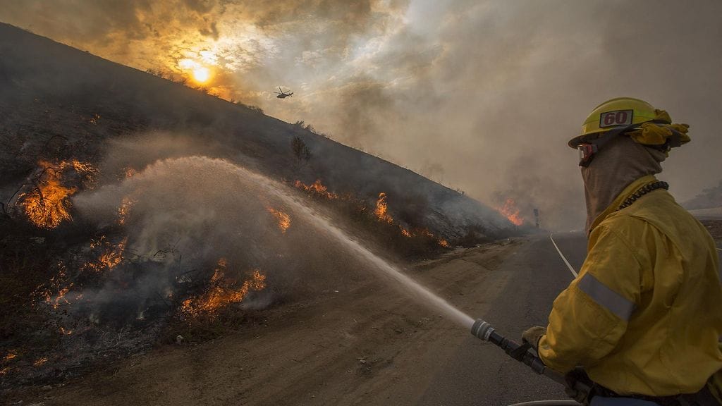 Palomies koittaa saada paloa hallintaan.