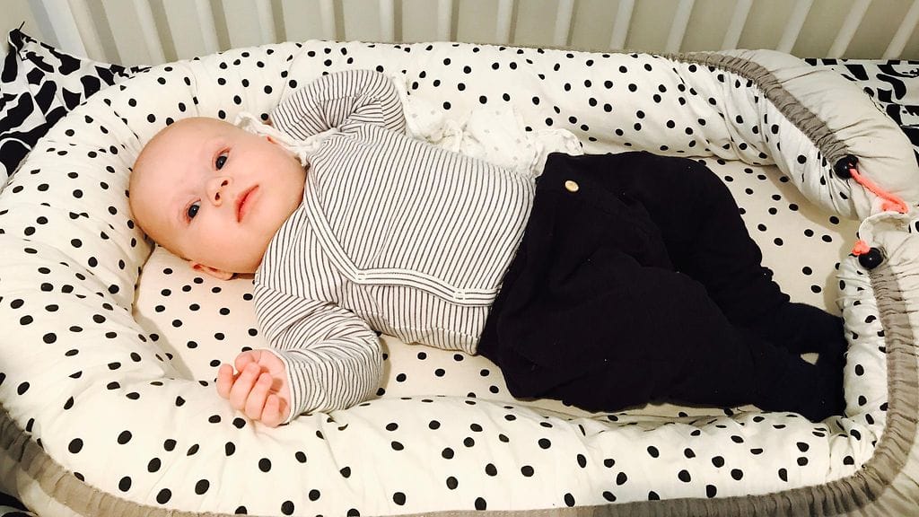 vauva selällään sängyssä