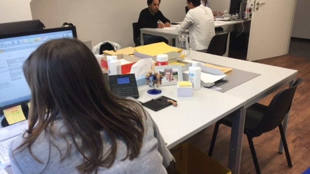 Liittovaltion pakolaisviraston työntekijät tarkistavat turvapaikkaa hakevan syyrialaismiehen (selin) tietoja Giessenin pakolaiskeskuksessa. Kun tiedot on tarkistettu, turvapaikkapäätöksen tekevä virkailija haastattelee hakijaa. Saksassa on tänä vuonna tehty jo lähes 400000 turvapaikkapäätöstä. Niistä 44% on ollut kielteisiä.