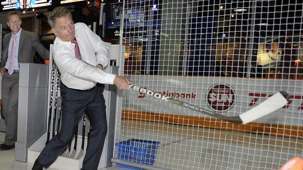 Sauli Niinistö laukoi kiekkoja tutustuessaan Saku Koivun opastuksella Hockey Hall of Fame -museoon vuonna 2014